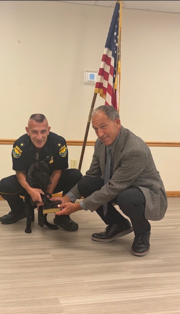 Police officers pose with K9 Bane